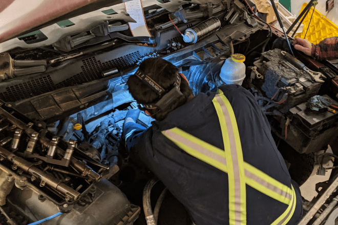 Kolby White working in an engine compartment as a Red Seal mechanic